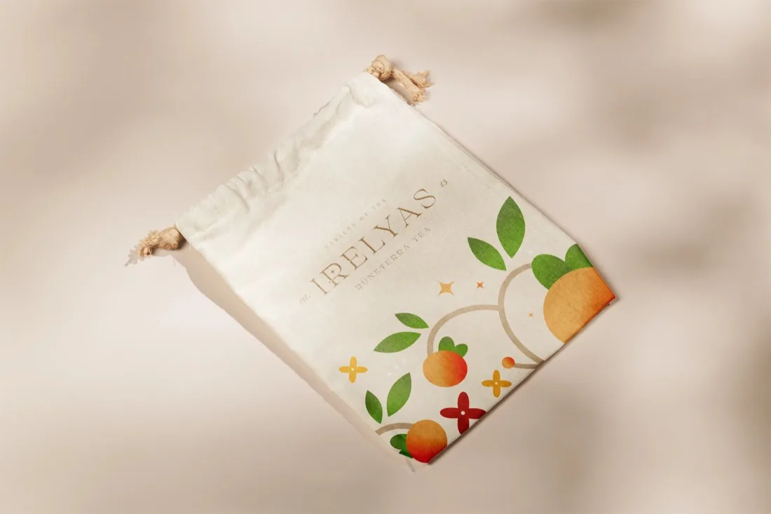 Bolsa de tela para té IRELYAS, ilustrada con hojas verdes y frutos naranjos y cerrada con un cordel