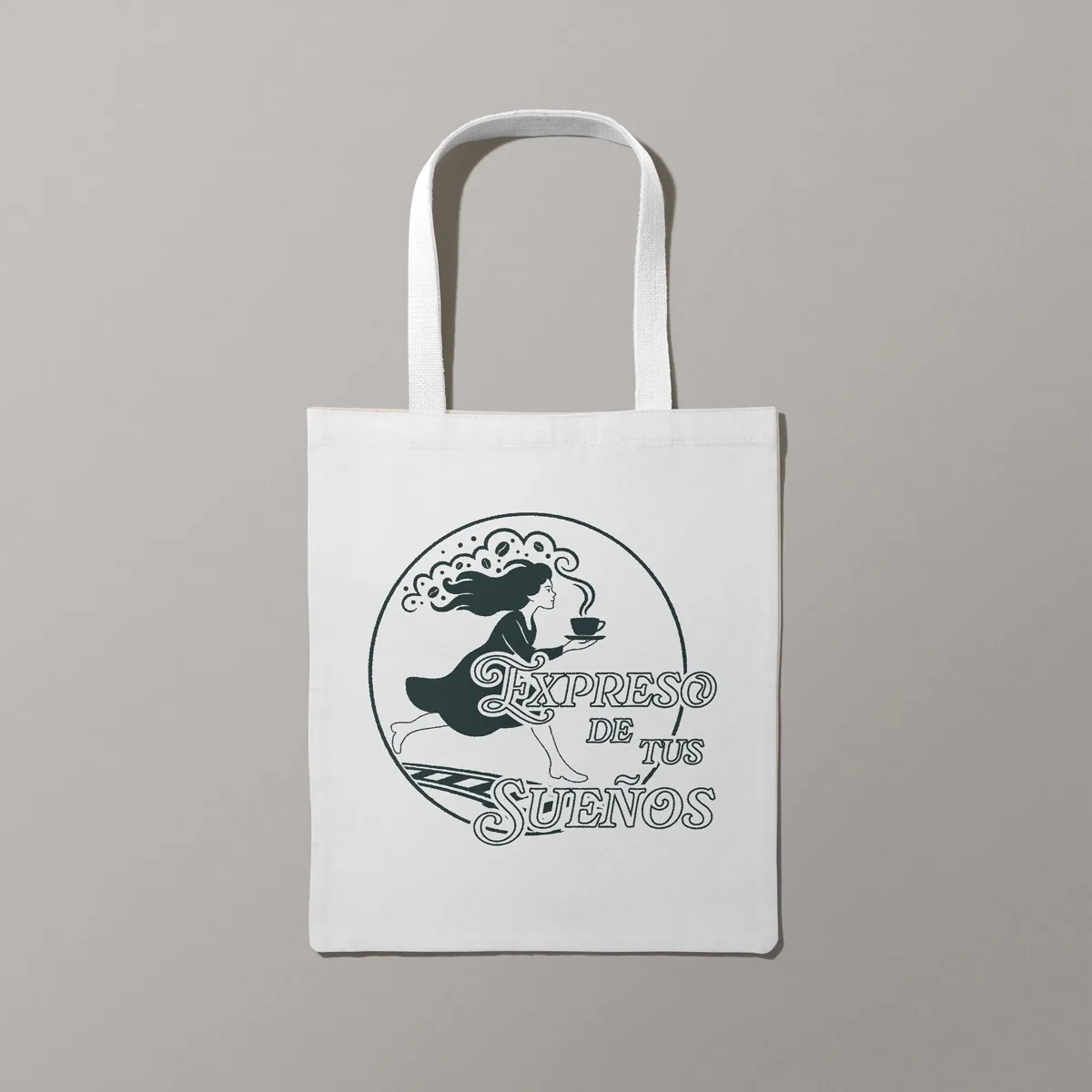 Bolsa de tela blanca con el sello circular de Expreso de tus Sueños: la soñadora corre con una taza sobre los rieles