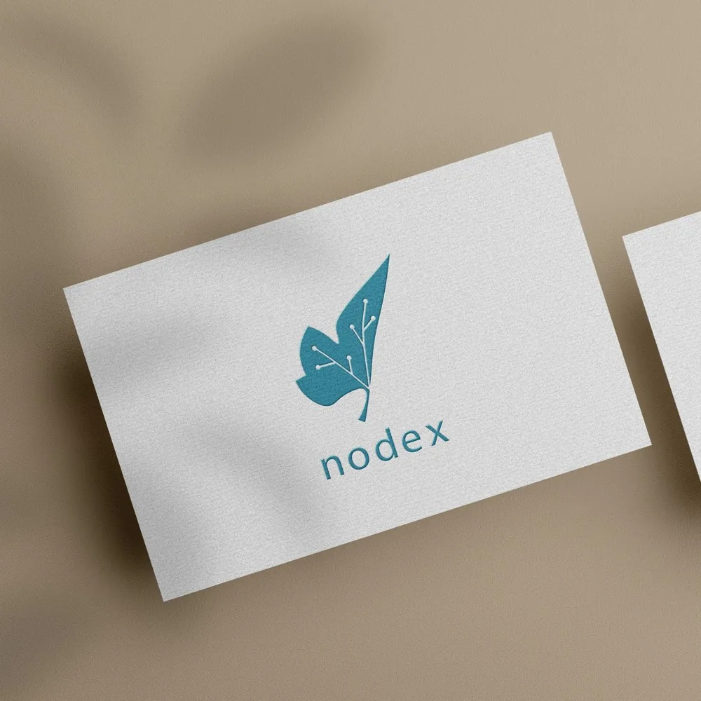 Tarjeta blanca de Nodex con la hoja-circuito turquesa en relieve, bajo sombras de hojas sobre fondo topo